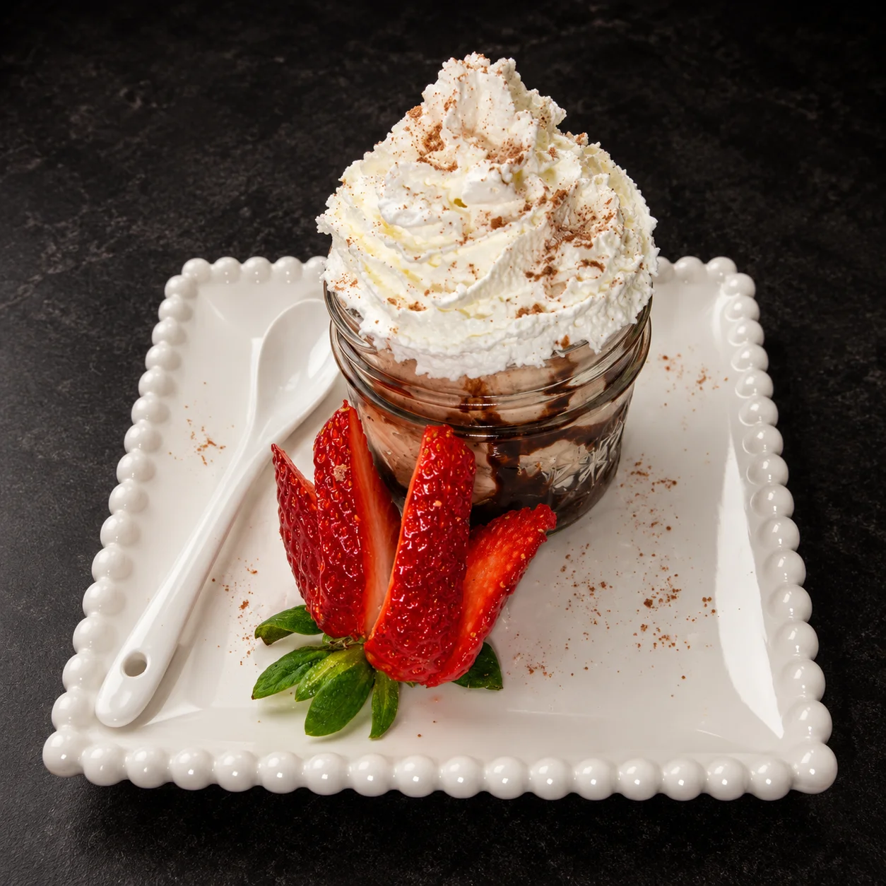 Postre en frasco con crema batida y fresas